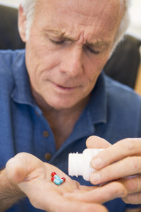 Pharmaceutical Malpractice Senior Man Pouring Pills Out Of Bottle